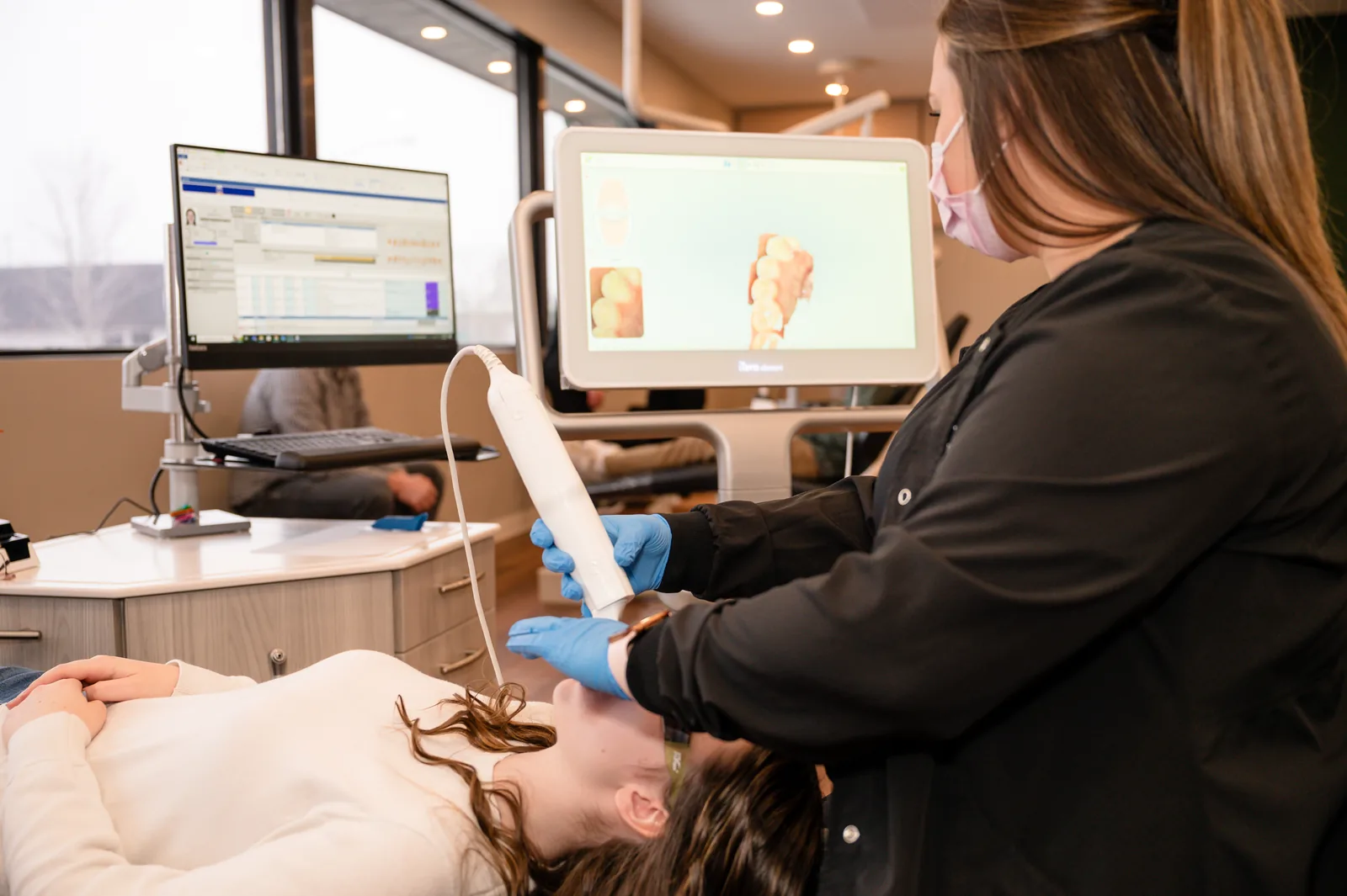 Sytek Ortho team member taking a digital intraoral scan while the 3D model builds on the monitor