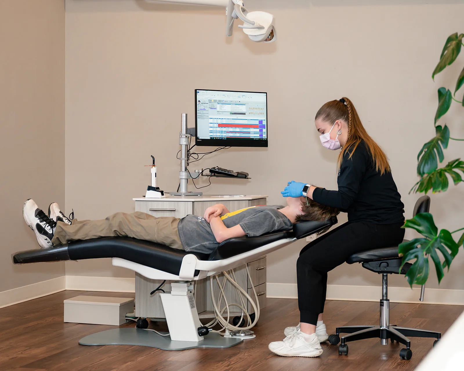 A Sytek Ortho team member reviewing a patient's progress on screen during a chairside visit