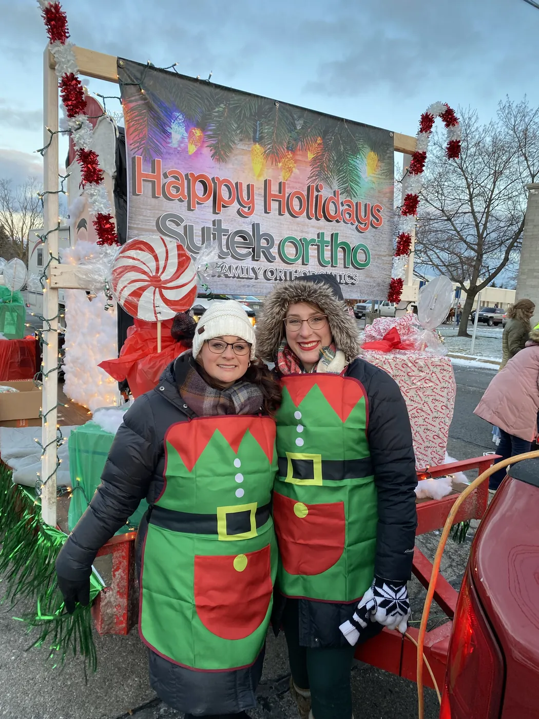 Two Sytek Ortho team members in elf costumes on the holiday parade float