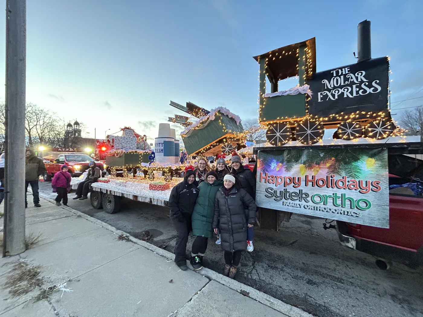 The Sytek Ortho team beside their Molar Express float at the Bolenz Holiday parade