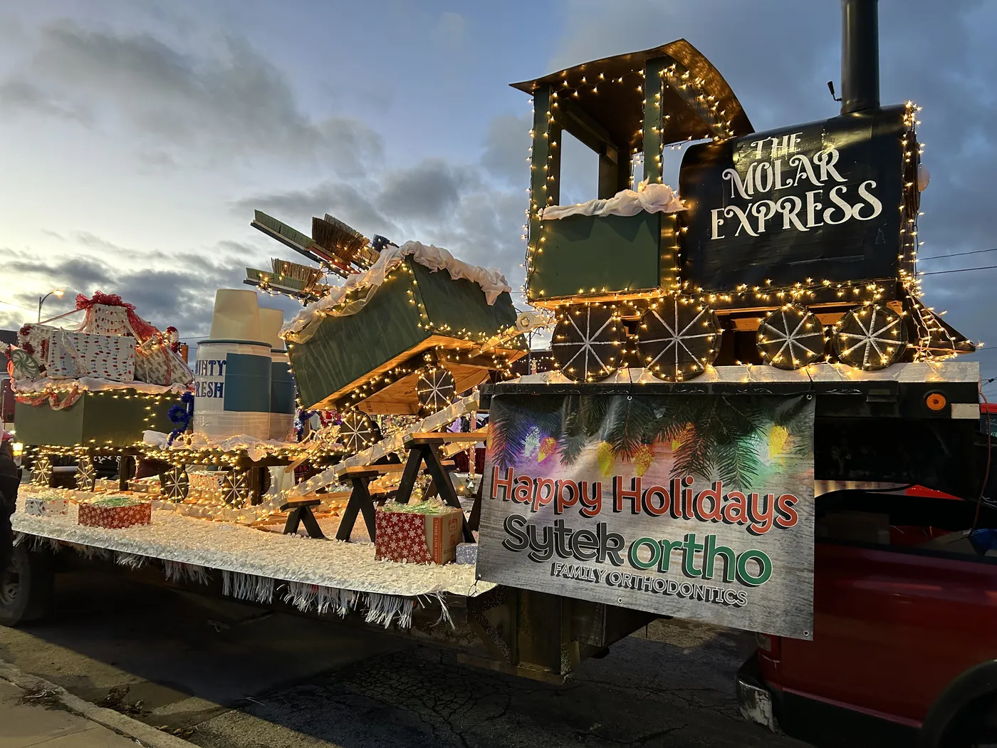 The Molar Express holiday parade float lit up at dusk